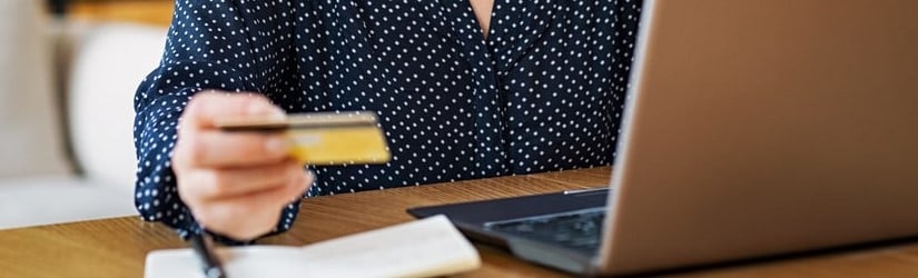 Jeune femme heureuse faisant du shopping en ligne avec son ordinateur portable à la maison. 